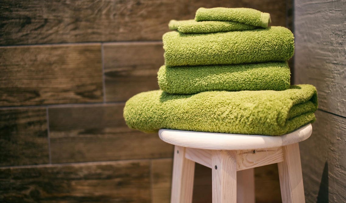 Green towels on wooden round table 