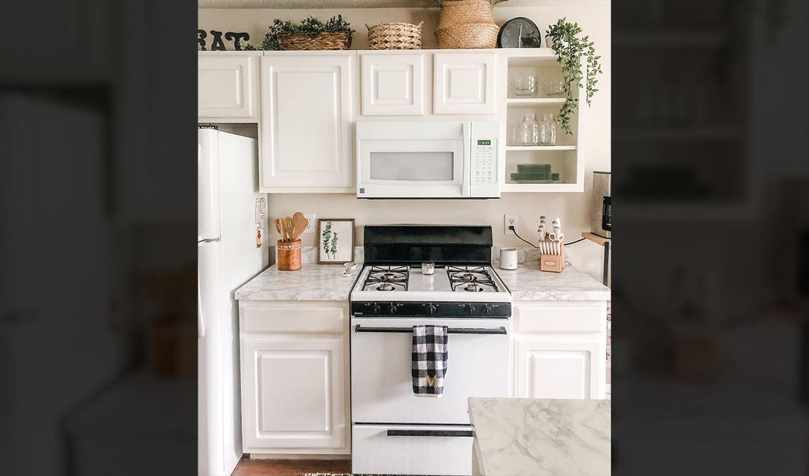 white kitchen with marble countertop and microwave 