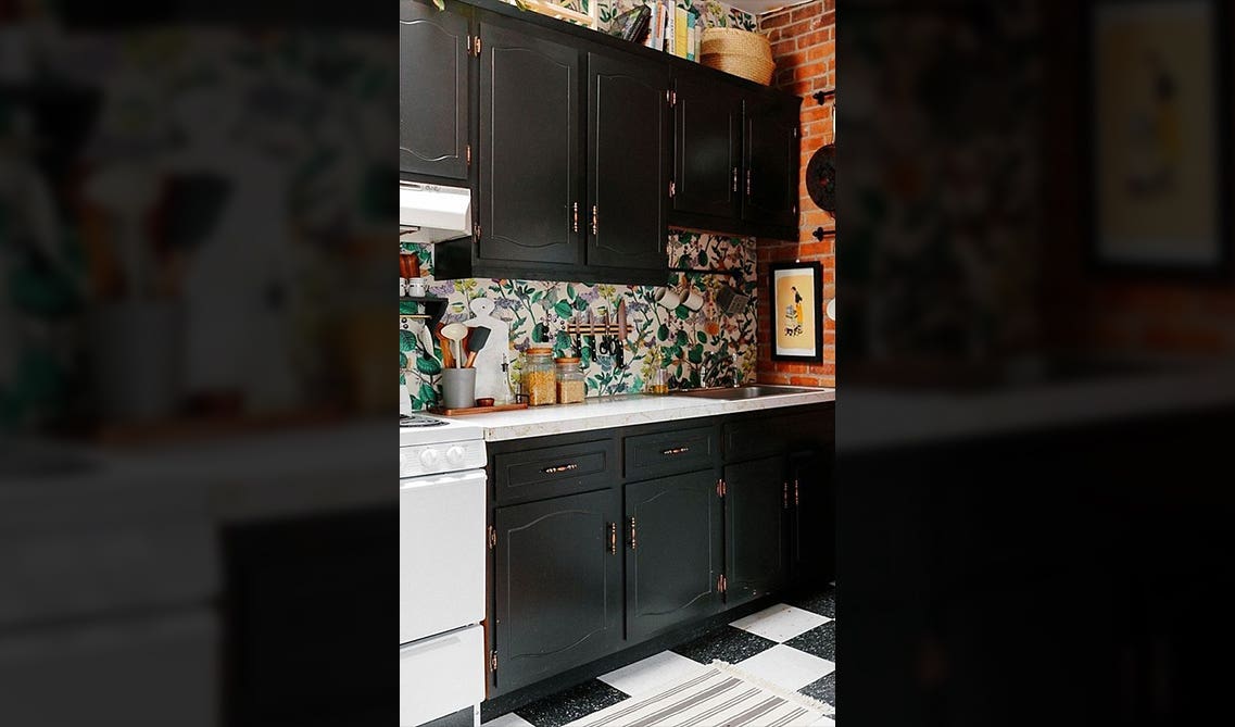 Printed wallpaper with black kitchen cabinets 