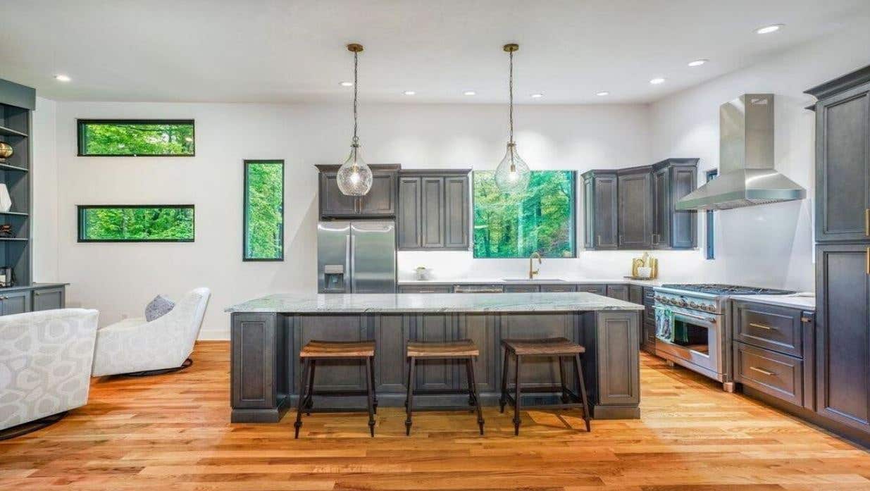 Gray kitchen cabinets with large gray island and light fixture